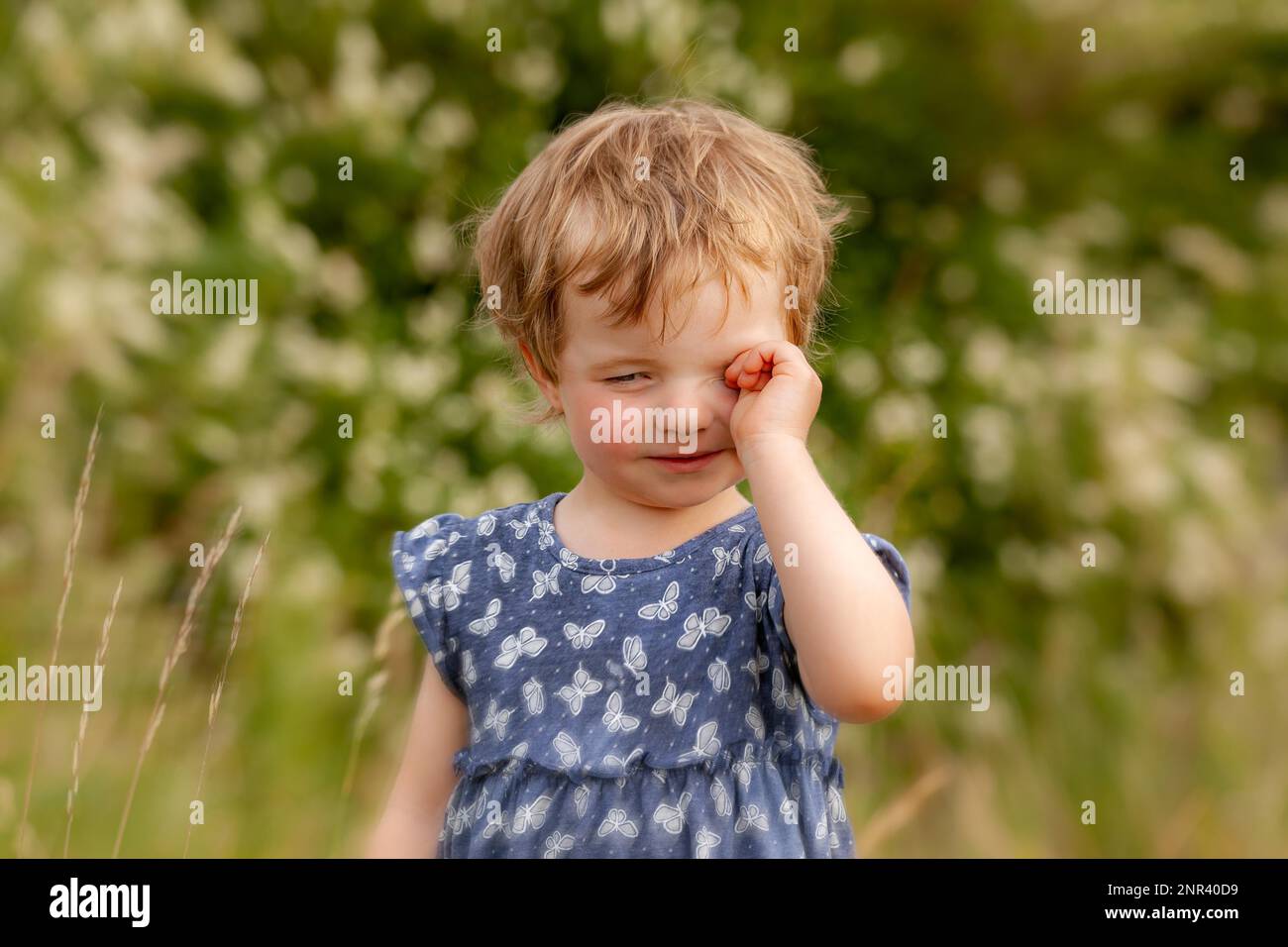 L'enfant frotte ses yeux fatigués Banque D'Images