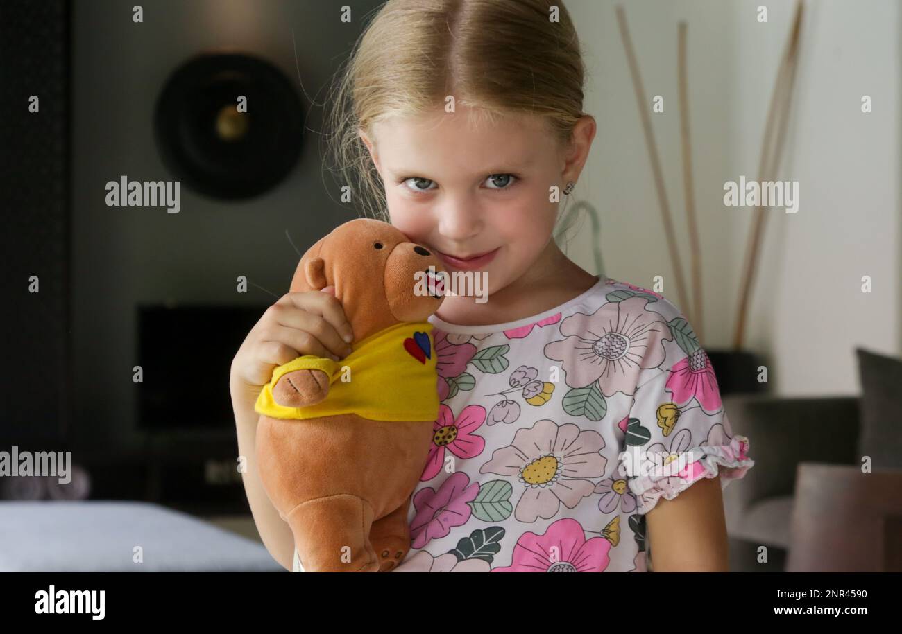 Adorable petite fille embrassant son ours en peluche Banque D'Images