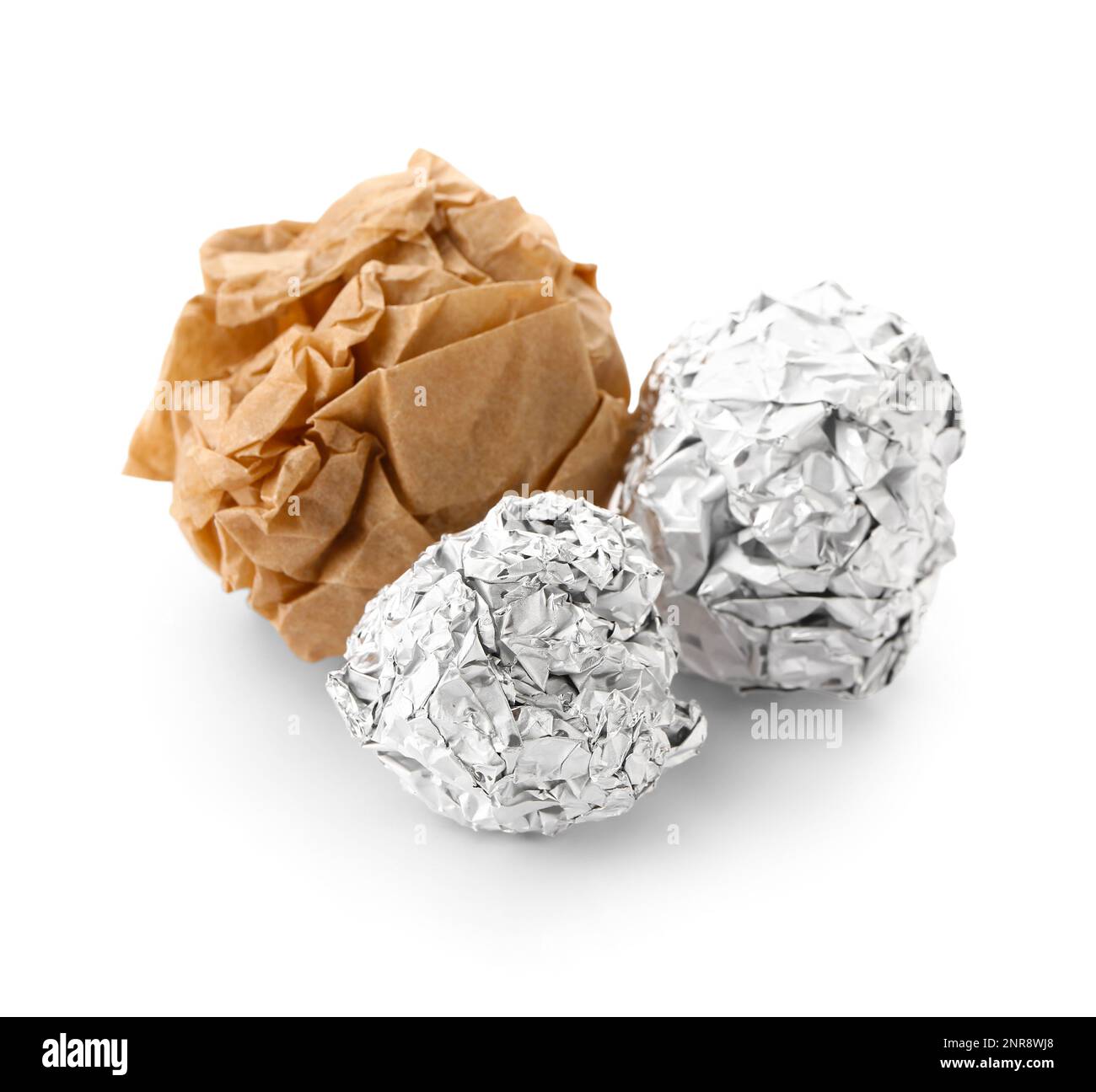 Des boules de papier aluminium froissé et de papier de cuisson sur fond blanc Banque D'Images
