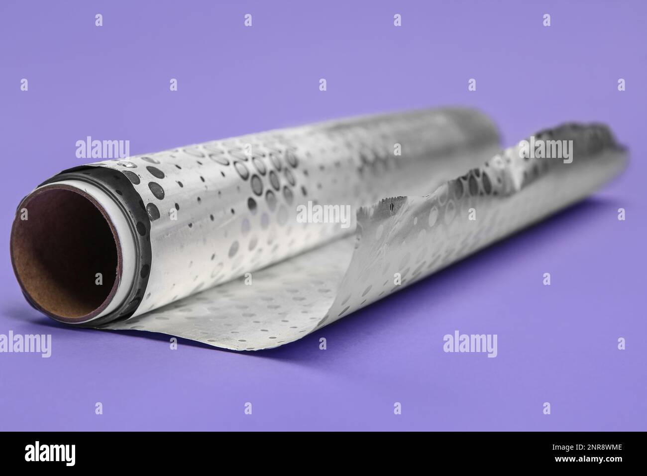 Rouleau de papier d'aluminium sur fond lilas, gros plan Banque D'Images