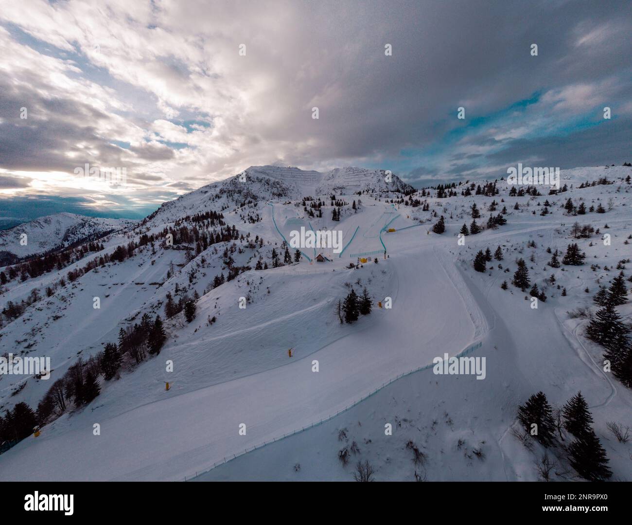 Panorama aérien par drone de la station de ski de Zoncolan, dans le nord de l'Italie, par une journée d'hiver nuageux. Montagnes visibles autour, bonne visibilité. Banque D'Images