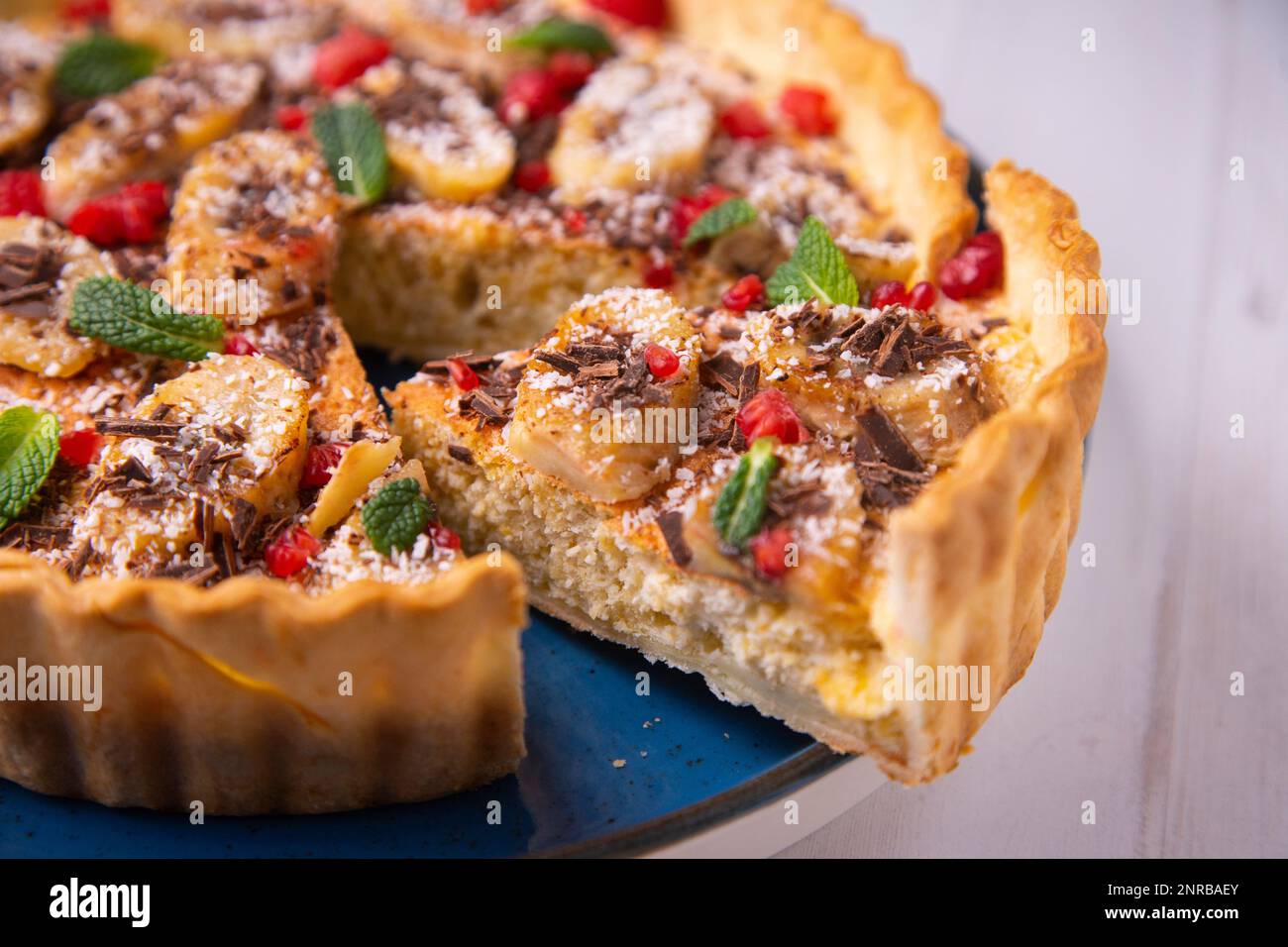 Gâteau éponge au yaourt à la banane avec des morceaux de fruits frais et de chocolat sur le dessus Banque D'Images