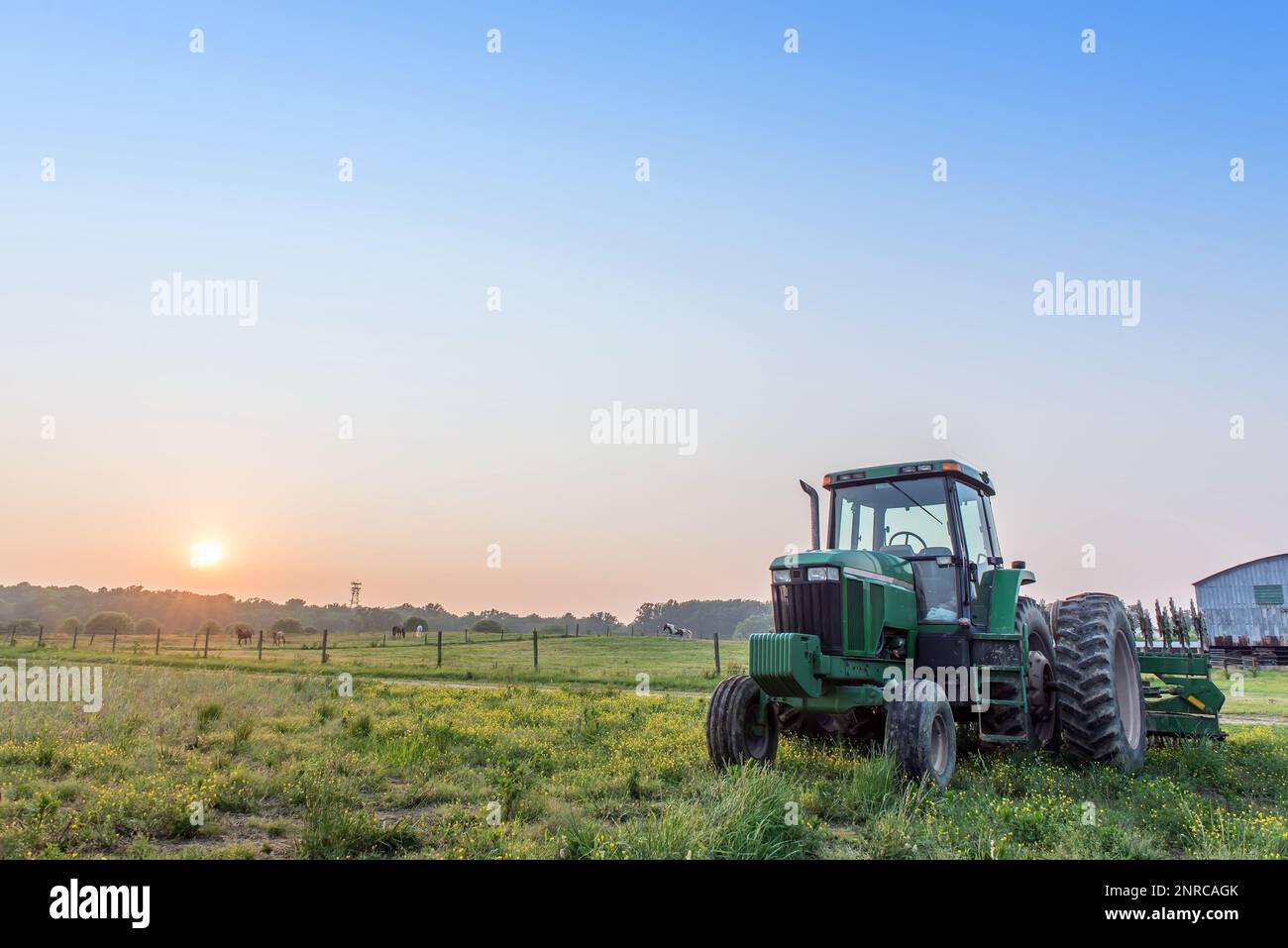 Paysage agricole d'un tracteur dans un champ sur une ferme du Maryland avec le coucher du soleil. Banque D'Images