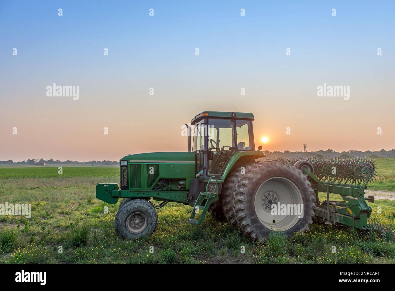 Paysage agricole d'un tracteur dans un champ sur une ferme du Maryland avec le coucher du soleil. Banque D'Images