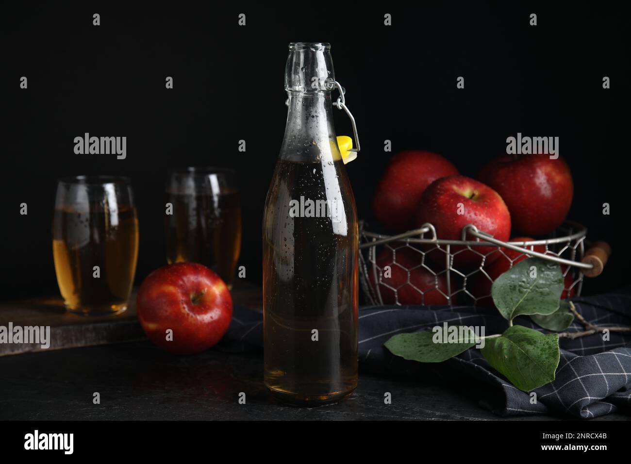 Composition avec un délicieux cidre de pomme sur table noire Banque D'Images