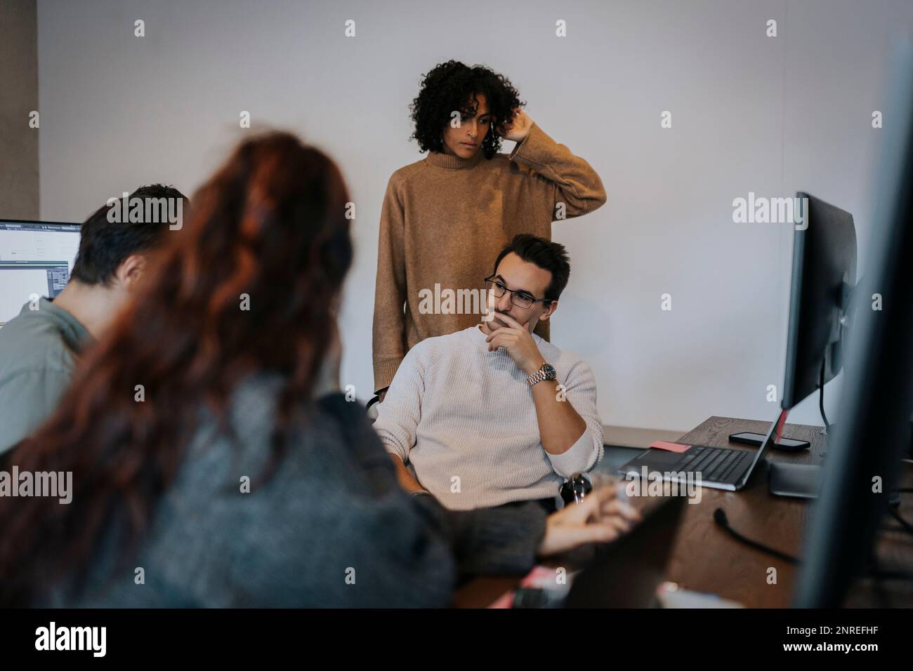 Programmeurs d'ordinateur multiraciaux, hommes et femmes, discutant dans une entreprise de démarrage Banque D'Images