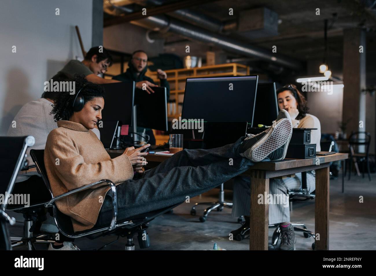 Femme entrepreneur utilisant le smartphone par des programmeurs d'ordinateur travaillant au bureau Banque D'Images