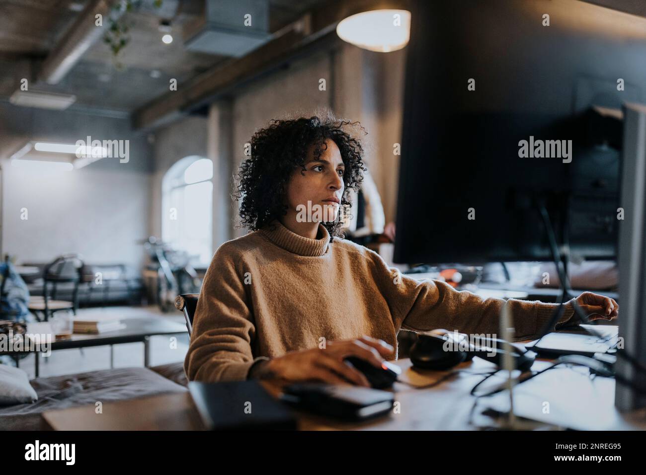 Une femme programmeuse se concentrant sur un ordinateur au bureau Banque D'Images