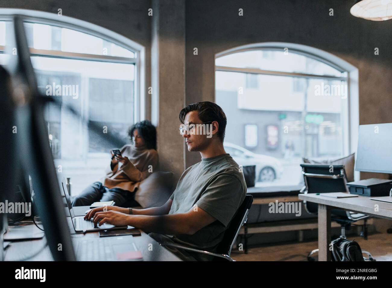 Programmeur d'ordinateur masculin utilisant un ordinateur portable lorsqu'il travaille dans une entreprise de démarrage Banque D'Images