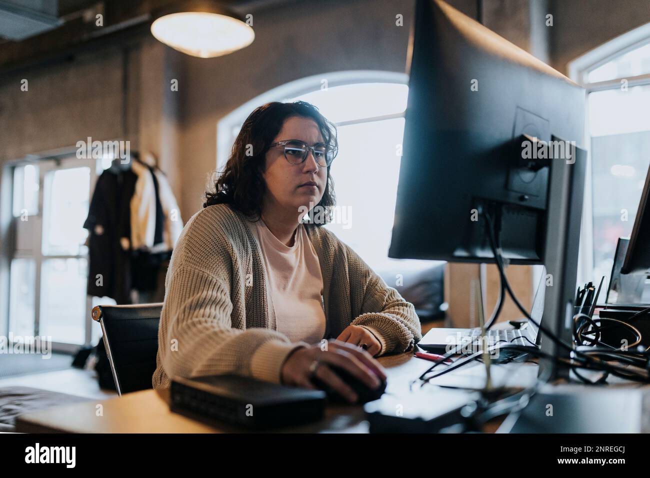 Femme d'affaires travaillant sur un ordinateur à un bureau dans une entreprise de démarrage Banque D'Images