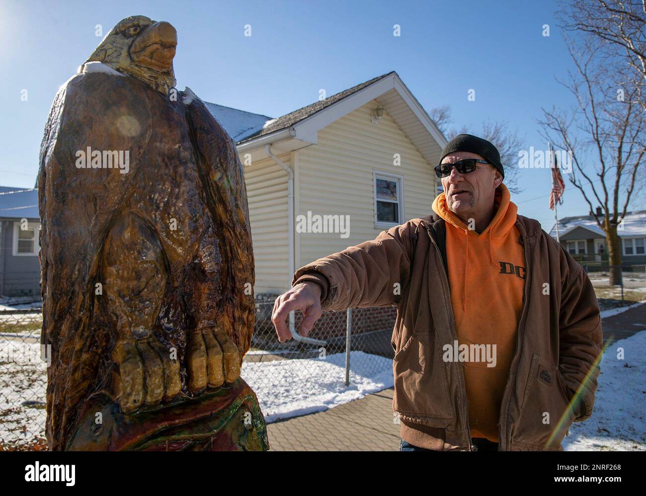 Scott Pries, owner of Scott's Custom Wood Carvings in Omaha, points out