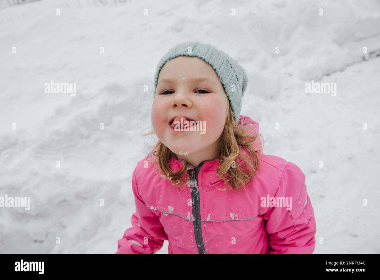 une jeune fille gaie attrape des flocons de neige avec sa langue Banque D'Images