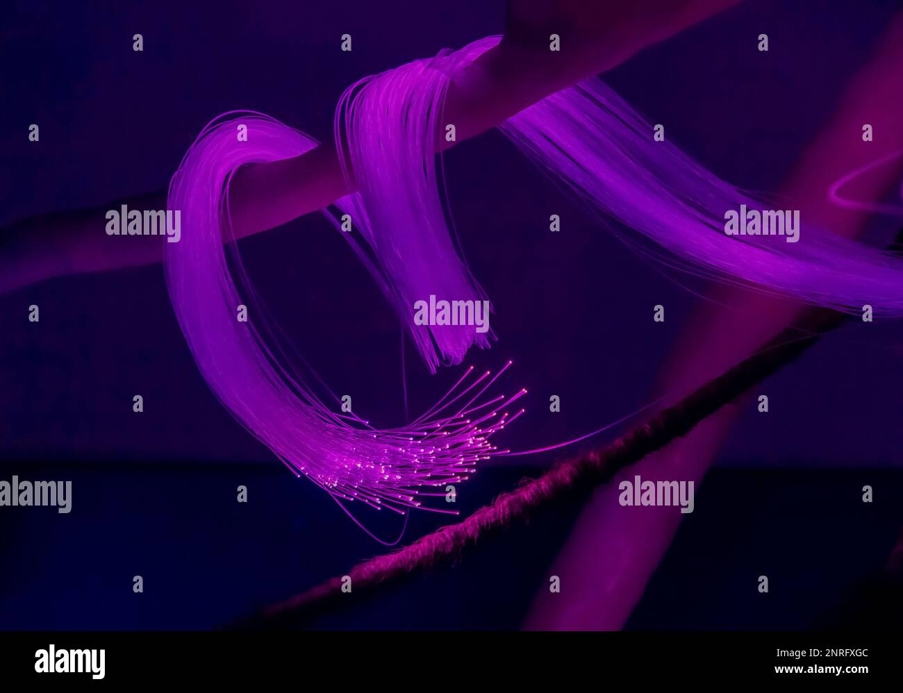 Fibres de verre illuminées avec branches et corde dans une ambiance sombre Banque D'Images