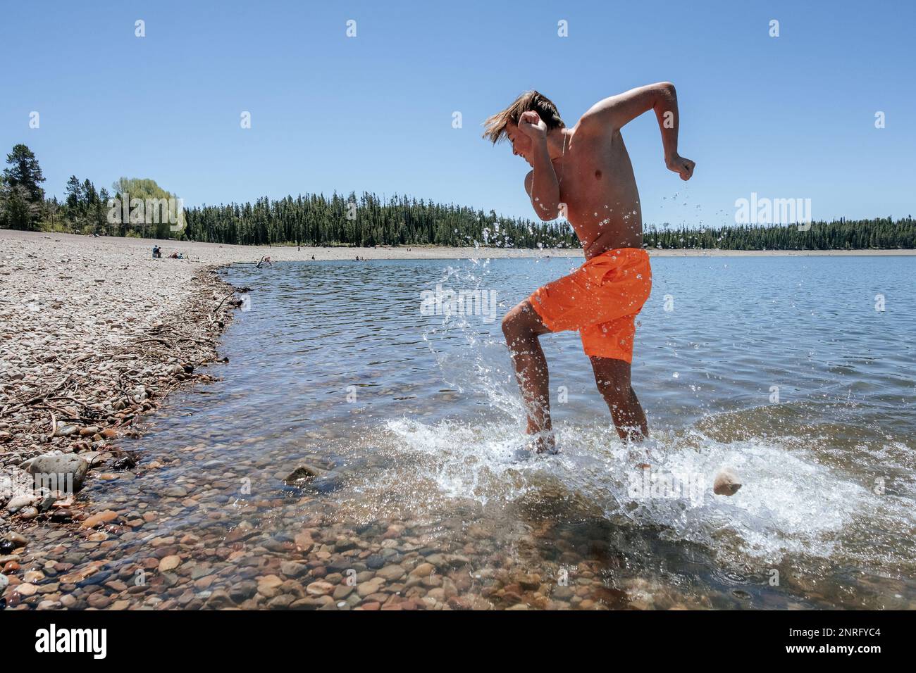 Un jeune garçon éclabousse de l'eau dans le lac Banque D'Images