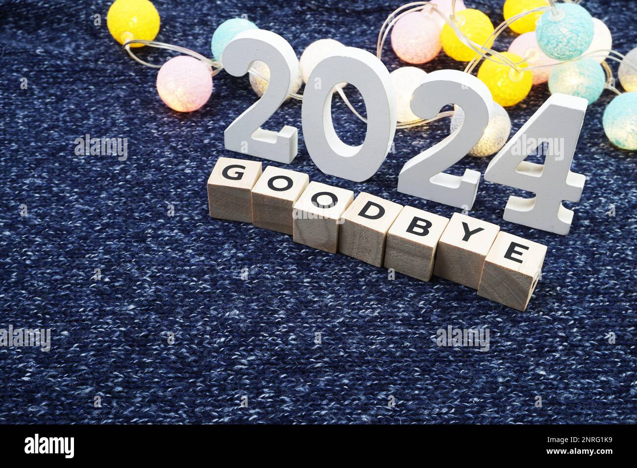 Au revoir 2024 lettre alphabet décorer avec boule de coton LED sur tissu tricoté bleu background4 Banque D'Images