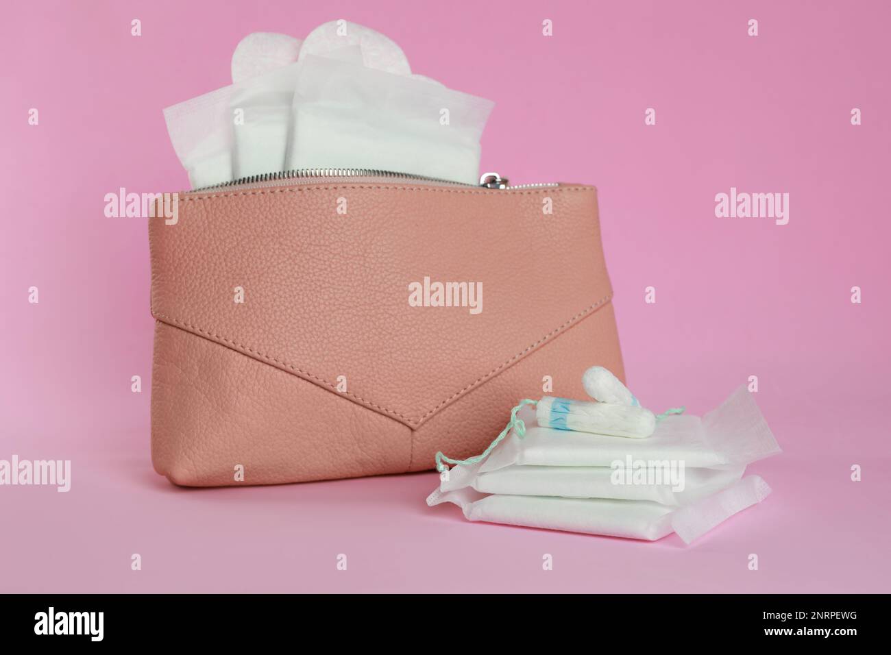 Sac avec tapis menstruels, pantyliners et tampons sur fond rose Banque D'Images