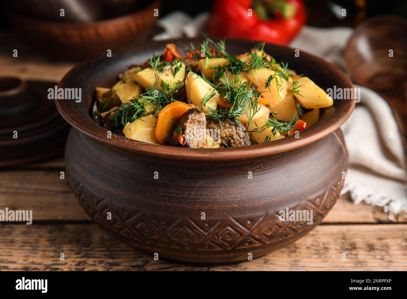Savoureux plat cuit avec des pommes de terre en faïence sur une table en bois Banque D'Images