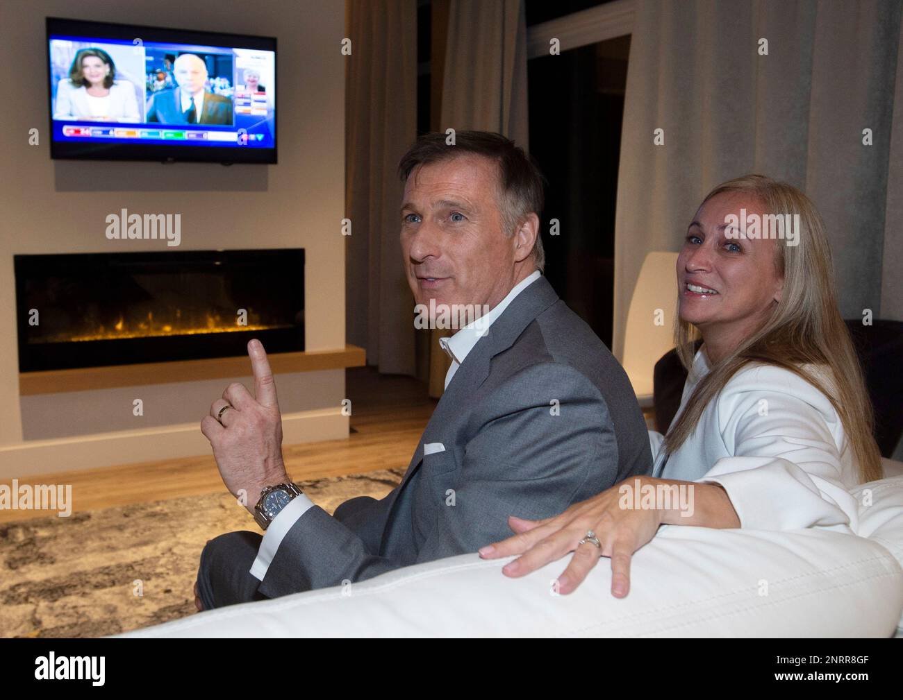 People's Party of Canada Leader Maxime Bernier and his wife, Catherine Letarte, watch election results on television, Monday, Oct. 21, 2019, in Beauceville, Quebec. (Jacques Boissinot/The Canadian Press via AP) Banque D'Images