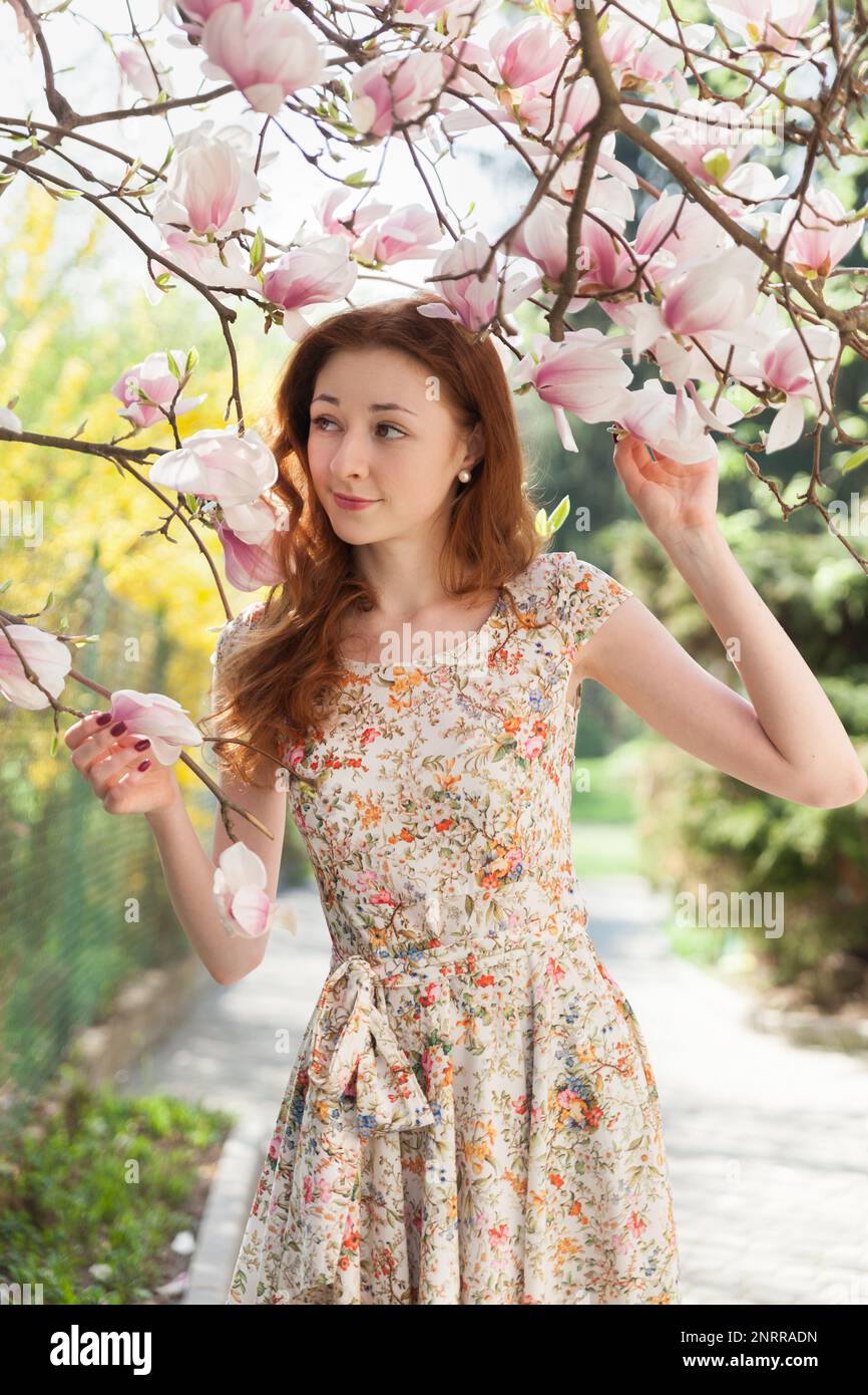 Jeune fille de cheveux de gingembre près rose clair tendre arbre de floraison. ambiance rêveur féérique du printemps et de l'été. Belle femme romantique souriante mariée, Banque D'Images
