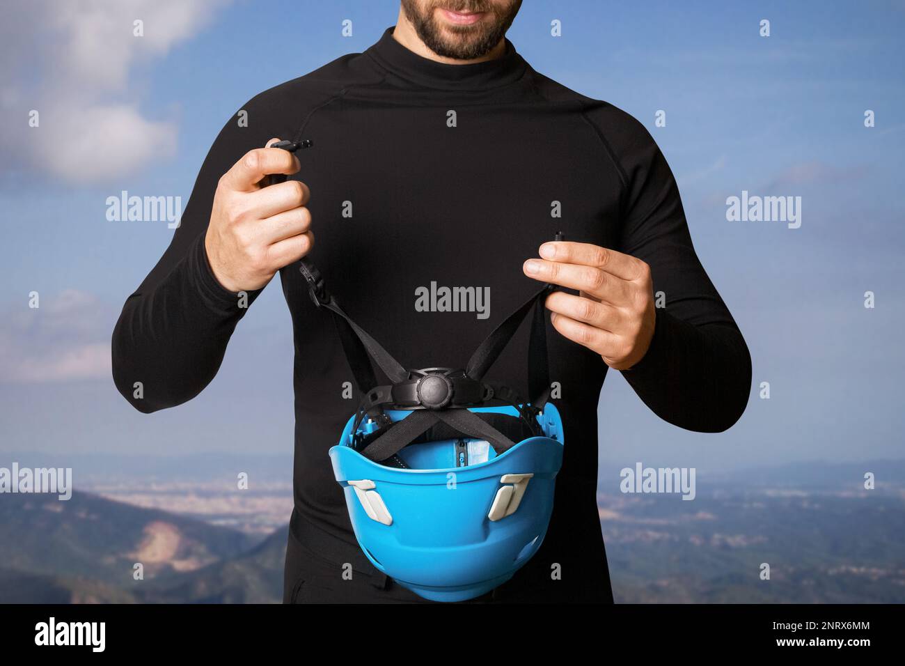 Homme, touriste, grimpeur. Avec un casque, un casque de protection dans ses mains. Dans les montagnes. Hauteur. Banque D'Images