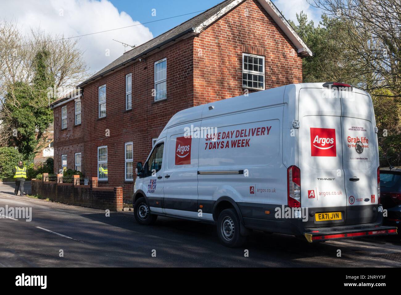 Camion de livraison Argos stationné dans un village du Hampshire avec un livreur, Angleterre, Royaume-Uni Banque D'Images
