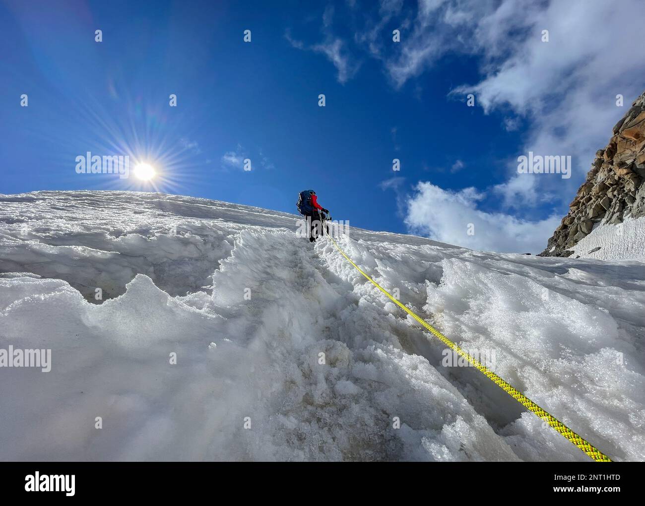 Deux grimpeurs grimpant en montée sur une pente enneigée en équipe de cordage le jour ensoleillé sous le Mont blanc du Tacul 4248m, Alpes françaises, France. Sports, escalade, Mo Banque D'Images