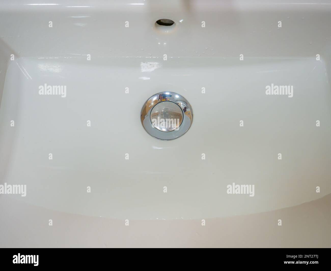 le bec d'un évier blanc avec de l'eau. Banque D'Images