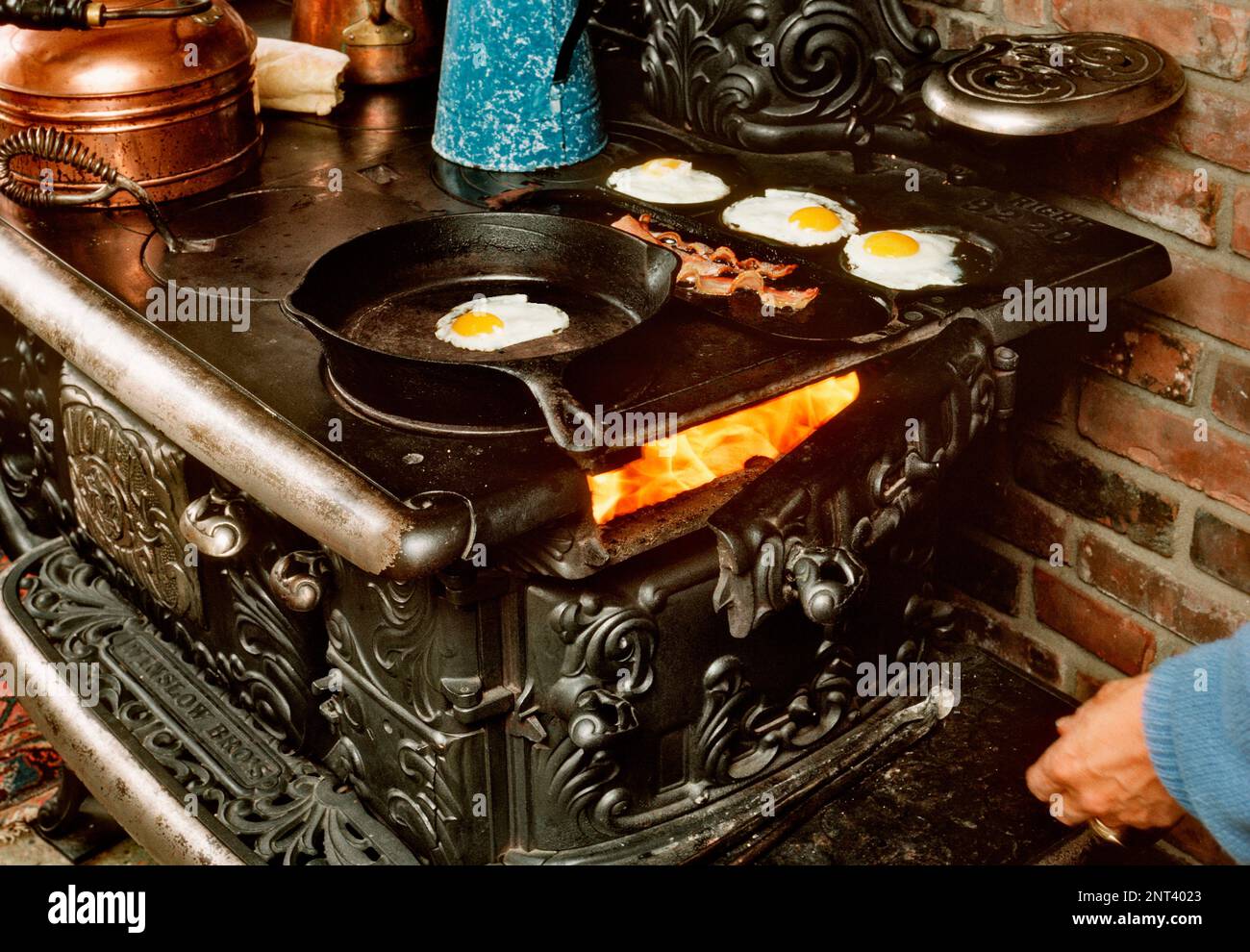 Le petit-déjeuner est cuisiné sur une vieille cuisinière en bois. Banque D'Images
