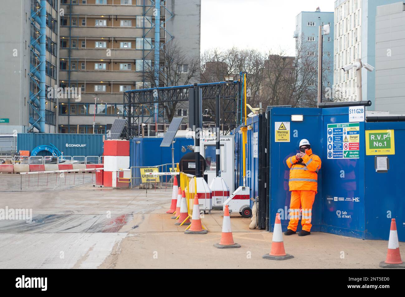 Euston, Londres, Royaume-Uni. 27th février 2023. An HS2 Security Guard filme un membre du public. HS2 Ltd effectue de vastes travaux de construction pour le nouveau train à grande vitesse 2 London Euston gare terminus et London Underground Interchange. HS2 a commencé des détournements d'utilitaires dans le chemin Euston la semaine dernière, ce qui ralentit maintenant la circulation. Les résidents vivant dans la région d'Euston doivent supporter HS2 bruits, poussières et perturbations qu'un résident a décrits aujourd'hui comme « l'enfer sur terre sans aucune fin en vue ». Crédit : Maureen McLean/Alay Live News Banque D'Images