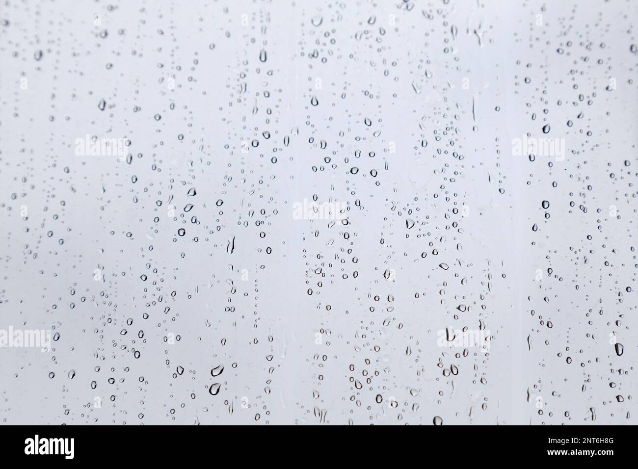 Gros plan sur les gouttes de pluie sur la fenêtre pendant la mousson. Banque D'Images