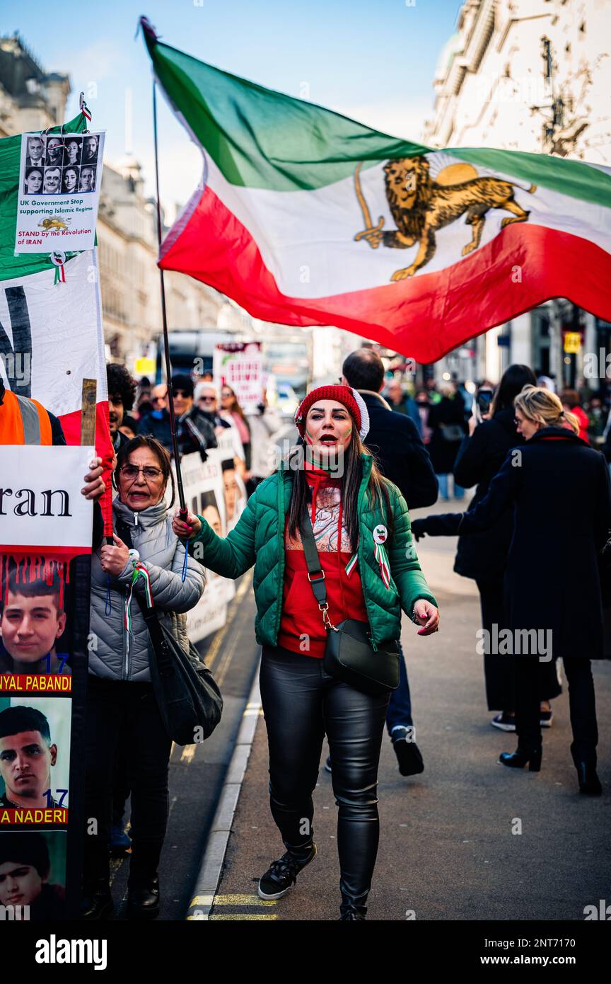 Femme marchant à Londres avec un drapeau pro-monarchie pour soutenir les femmes iraniennes et se tenant contre le régime actuel. Banque D'Images