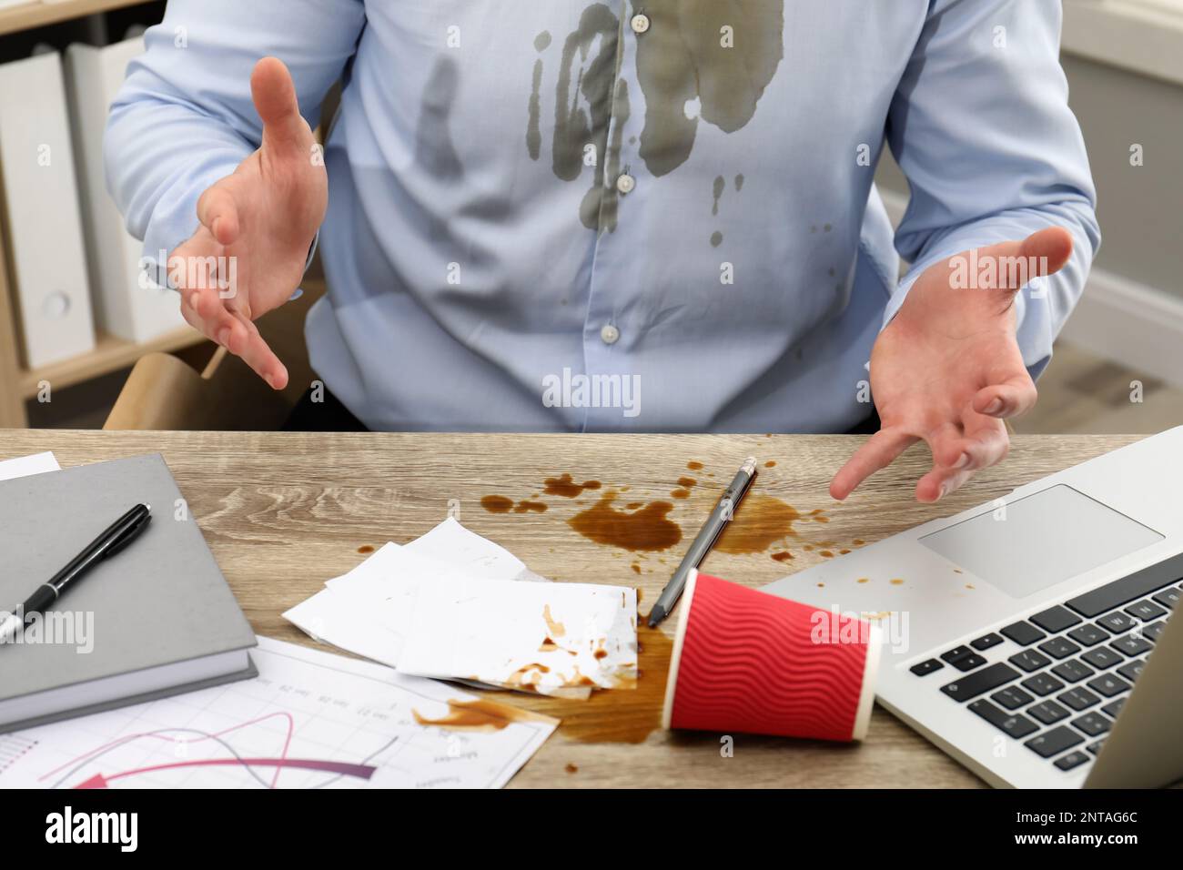 Homme avec du café renversé sur son lieu de travail et une chemise, gros plan Banque D'Images Homme avec du café renversé sur son lieu de travail et une chemise, gros plan Banque D'Images