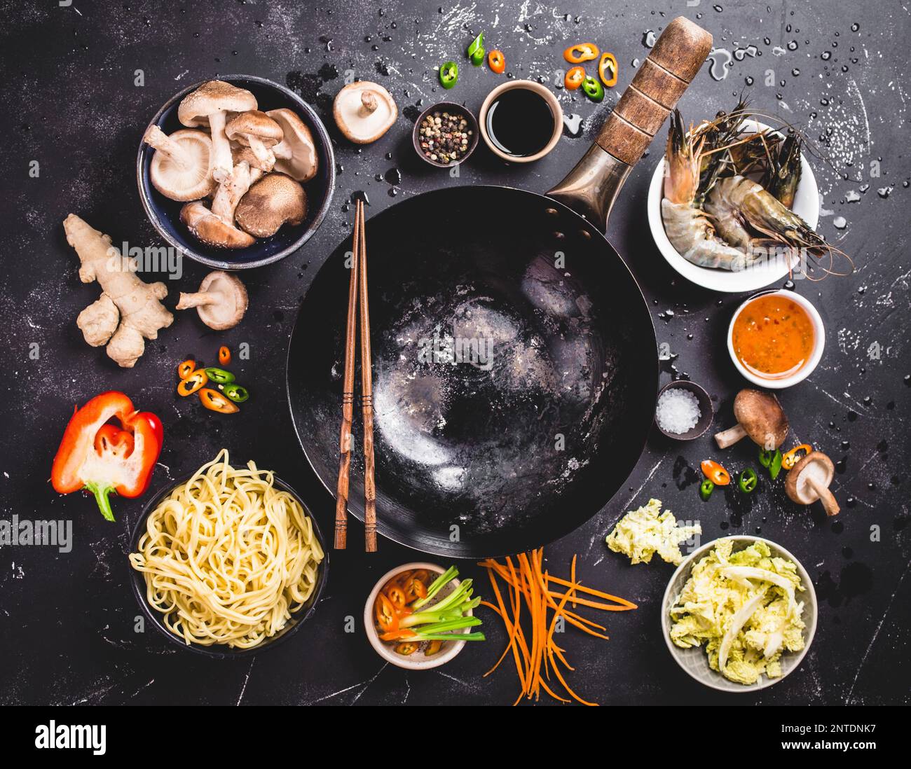 Cuisine asiatique. Poêle à wok vide, nouilles, légumes sautés, crevettes, sauces, baguettes. Cuisine asiatique/chinoise. Vue de dessus. Ingrédients pour Banque D'Images