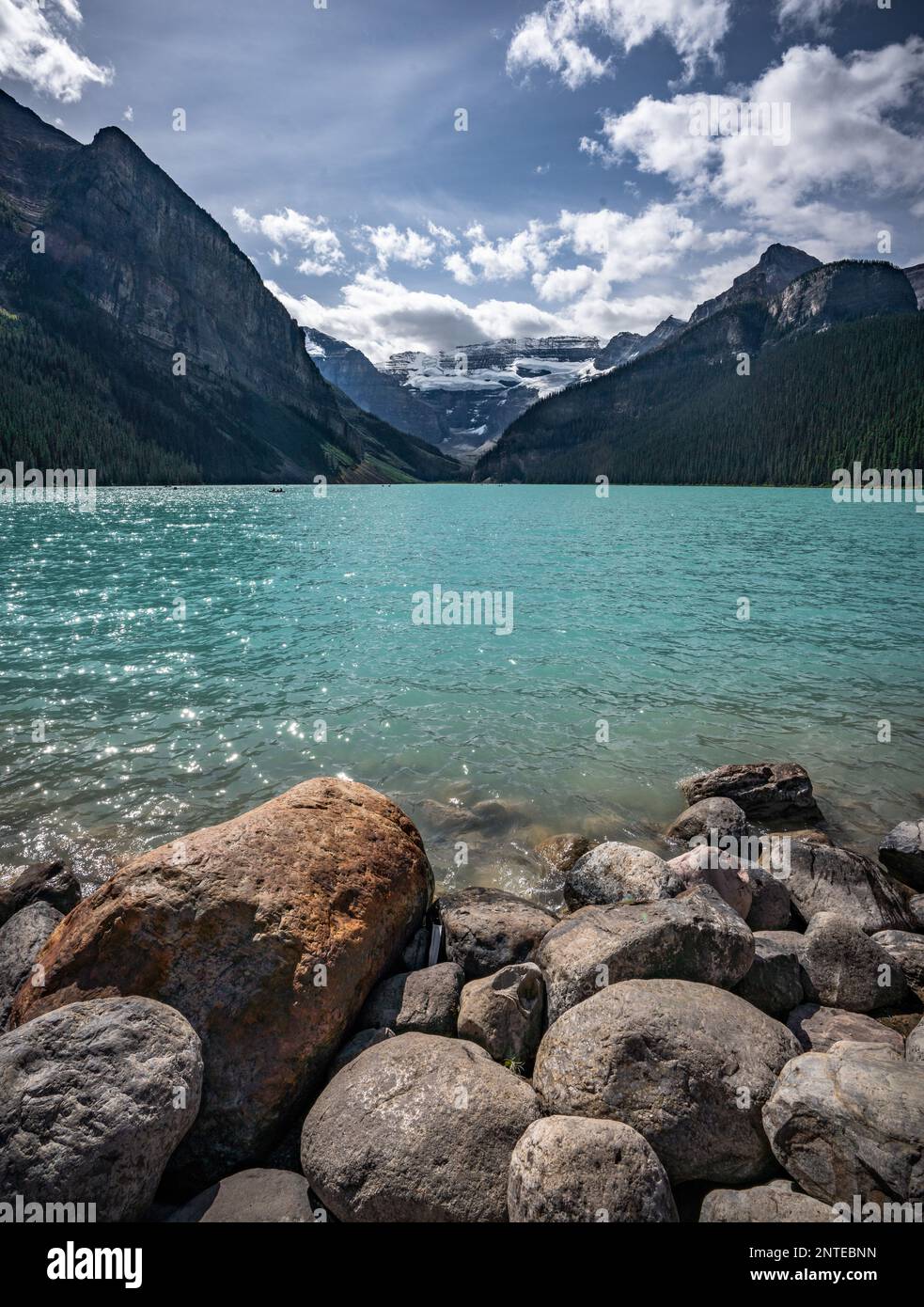 Vue imprenable sur le lac Louise avec vue sur le premier plan en pierre et le paysage rocheux des montagnes. Banque D'Images