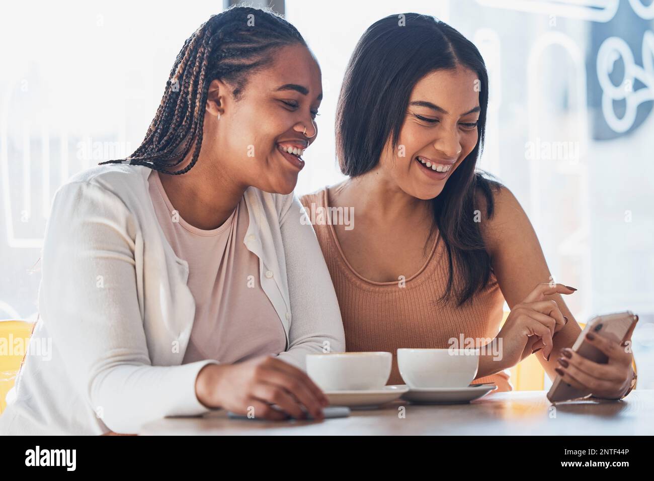 Amis femmes, café et téléphone avec sourire, heureux et rire à comic meme sur le réseau social. Gen z femme noire, smartphone et détendez-vous dans un café avec Banque D'Images