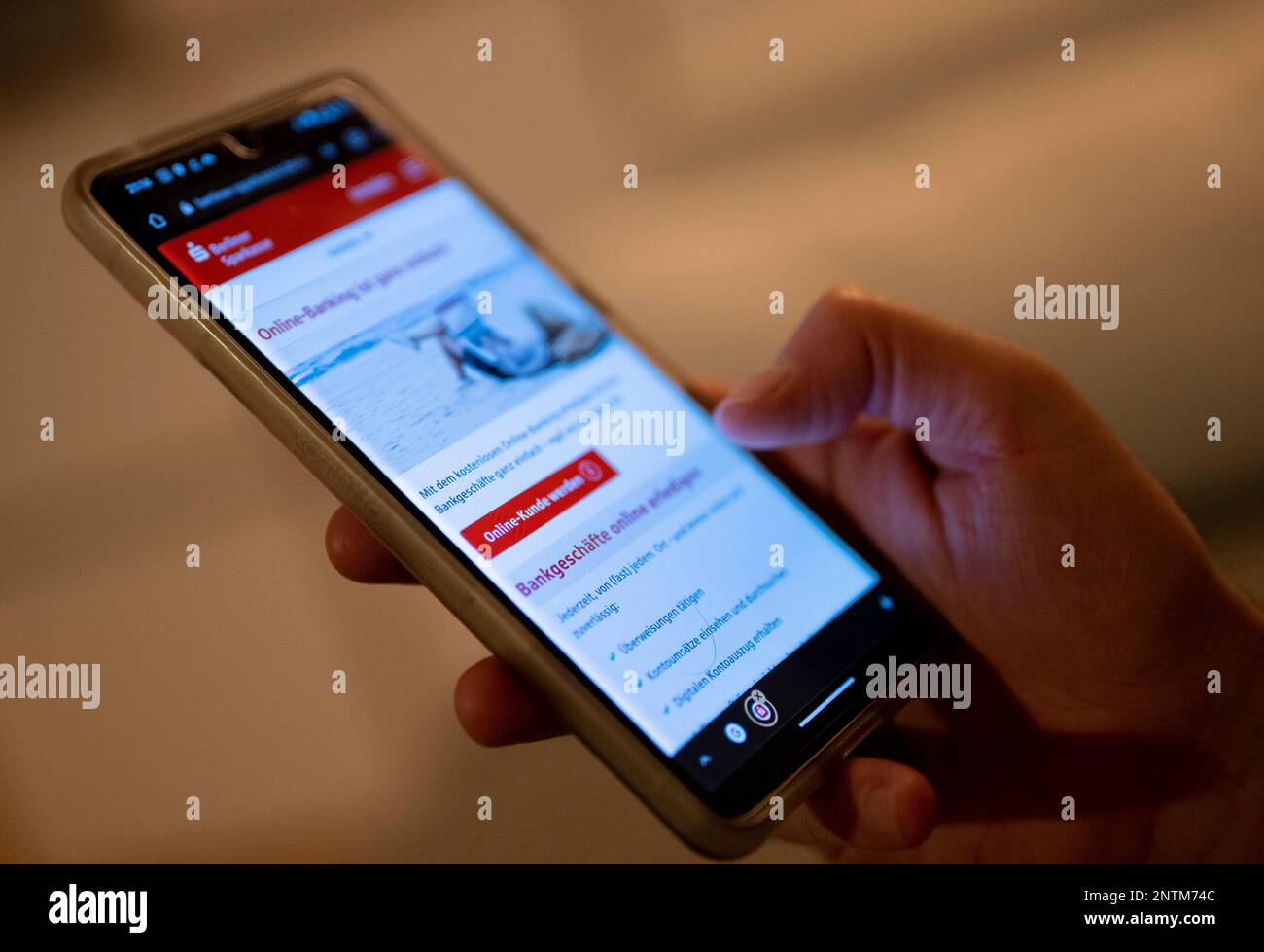 Berlin, Allemagne. 27th févr. 2023. Un homme tient un smartphone avec une page de banque en ligne ouverte. Credit: Monika Skolimowska/dpa/Alay Live News Banque D'Images