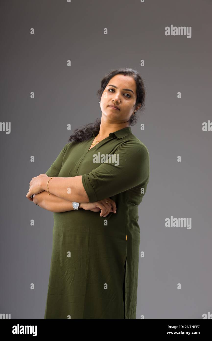 Portrait d'une femme indienne, posture debout montrant différents gesteurs, avec fond gris, isolé. Banque D'Images