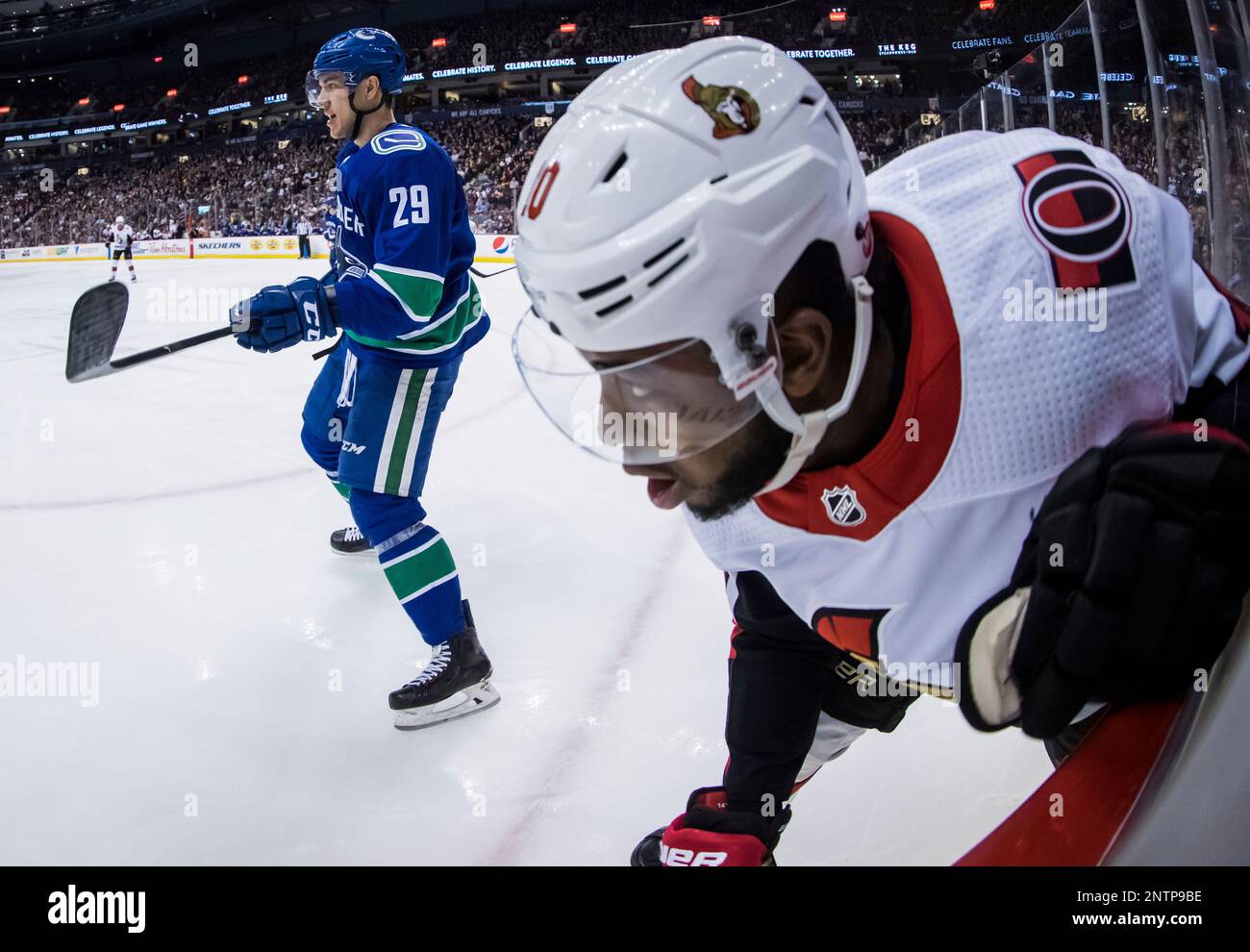 Ottawa Senators' Anthony Duclair, front right, crashes into the boards after being checked by Vancouver Canucks' Ashton Sautner, left, during the third period of an NHL hockey game Wednesday, March 20, 2019, in Vancouver, British Columbia. (Darryl Dyck/The Canadian Press via AP) Banque D'Images