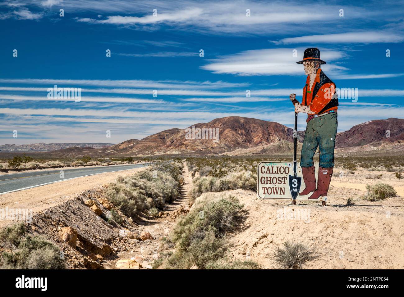 Figure pionnière, panneau criblé de trous de balle, sur la route de la ville fantôme de Calico, près de Barstow, désert de Mojave, Californie, États-Unis Banque D'Images