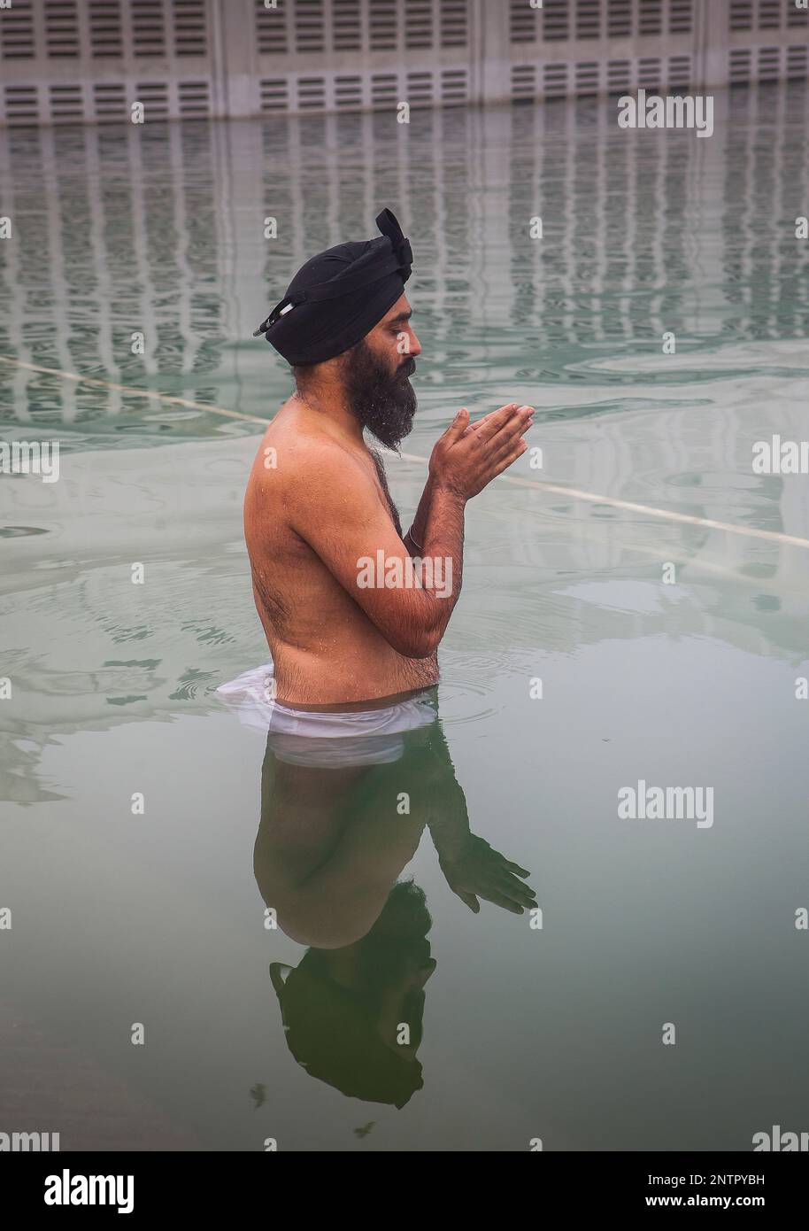 Pilgrim se baigner dans le bassin sacré Amrit Sarovar, Golden Temple, Amritsar, Punjab, India Banque D'Images