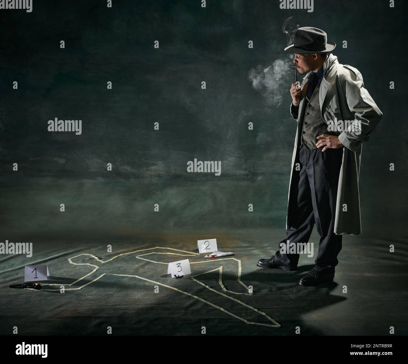 Portrait de l'homme, détective en trench-coat se tenant près de la silhouette humaine dessinée sur le sol et fumant pipe sur fond vert foncé vintage Banque D'Images