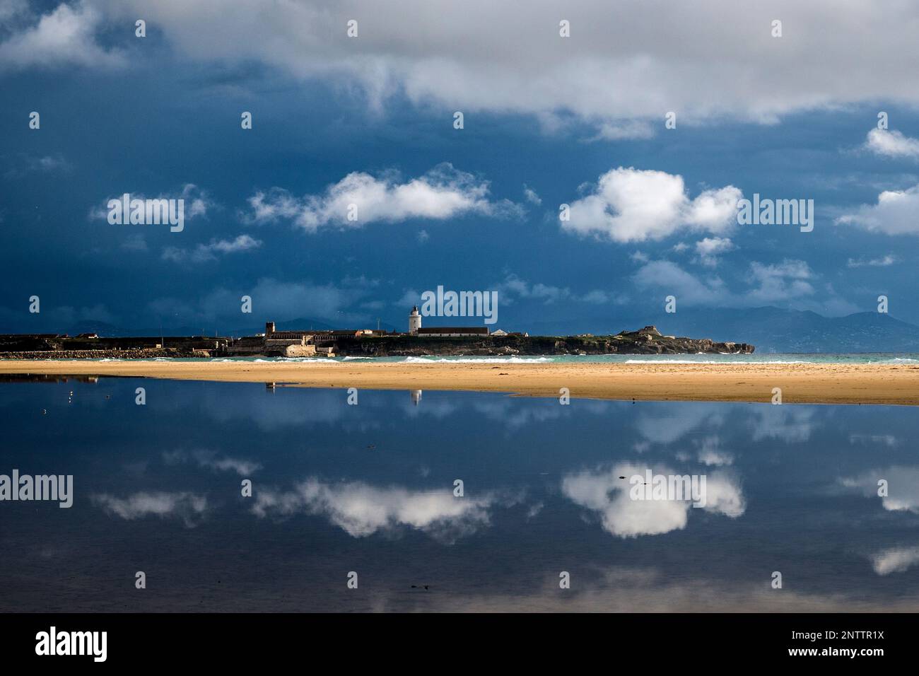 Phare de Tarifa situé dans l'île de Las Palomas se reflète sur la mer, Tarifa, province de Cadix, Andalousie, Espagne Banque D'Images