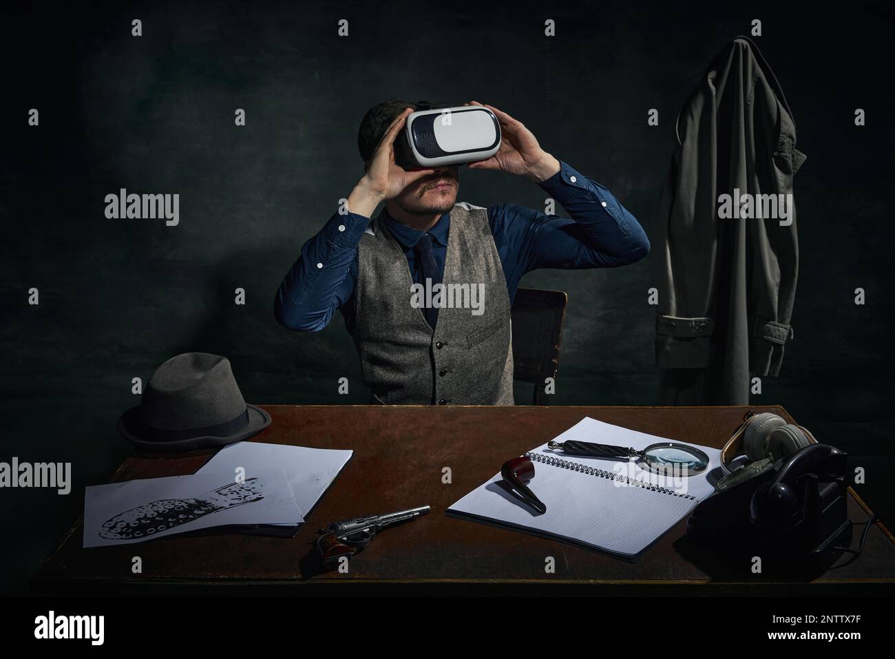 Détective professionnel dans les vêtements classiques et les lunettes de réalité virtuelle sur fond vert foncé vintage. Enquête. Technologies modernes Banque D'Images