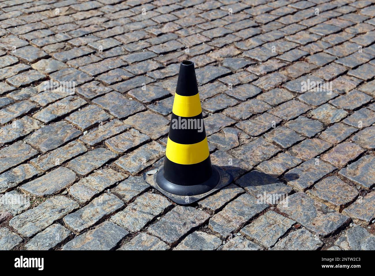 feu de signalisation de couleur jaune et noire, plastique dur, sur la voie publique en pierre Banque D'Images