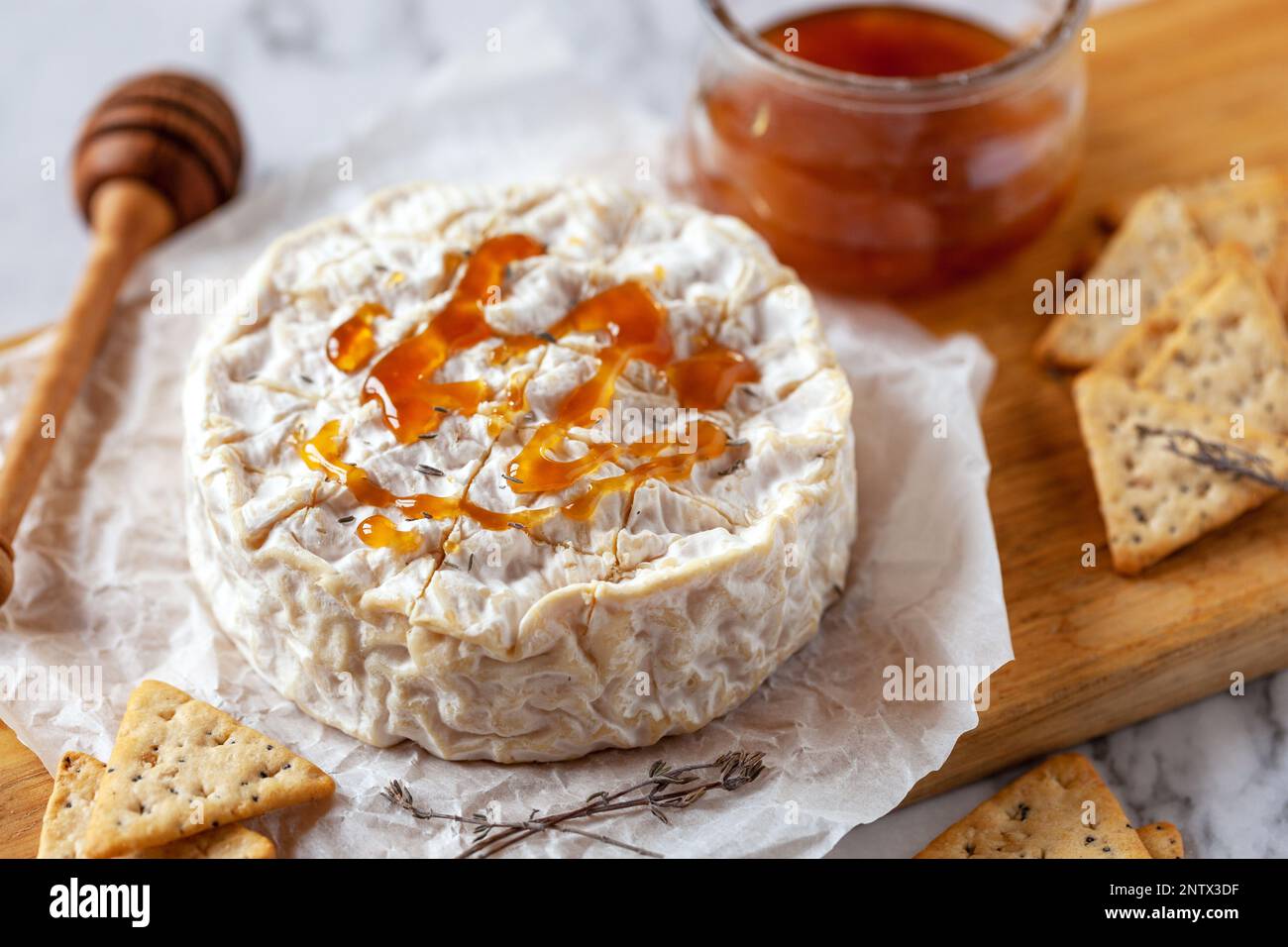 camembert, fromage français doux, servi avec du miel liquide et des craquelins, vue du dessus Banque D'Images