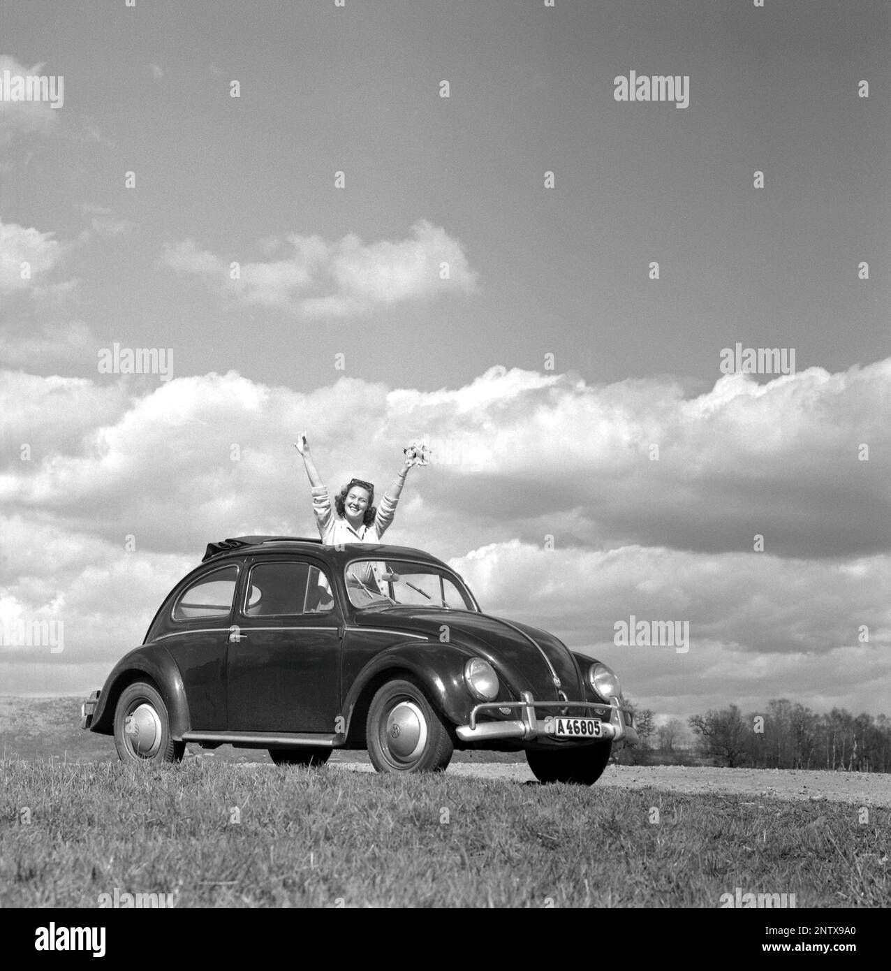 Dans le 1960s. L'actrice Gaby Stenberg semble heureuse ce jour d'été d'avoir le dessus de sa voiture de coléoptère Volkswagen. Suède 1960 Conard réf. 4232 Banque D'Images