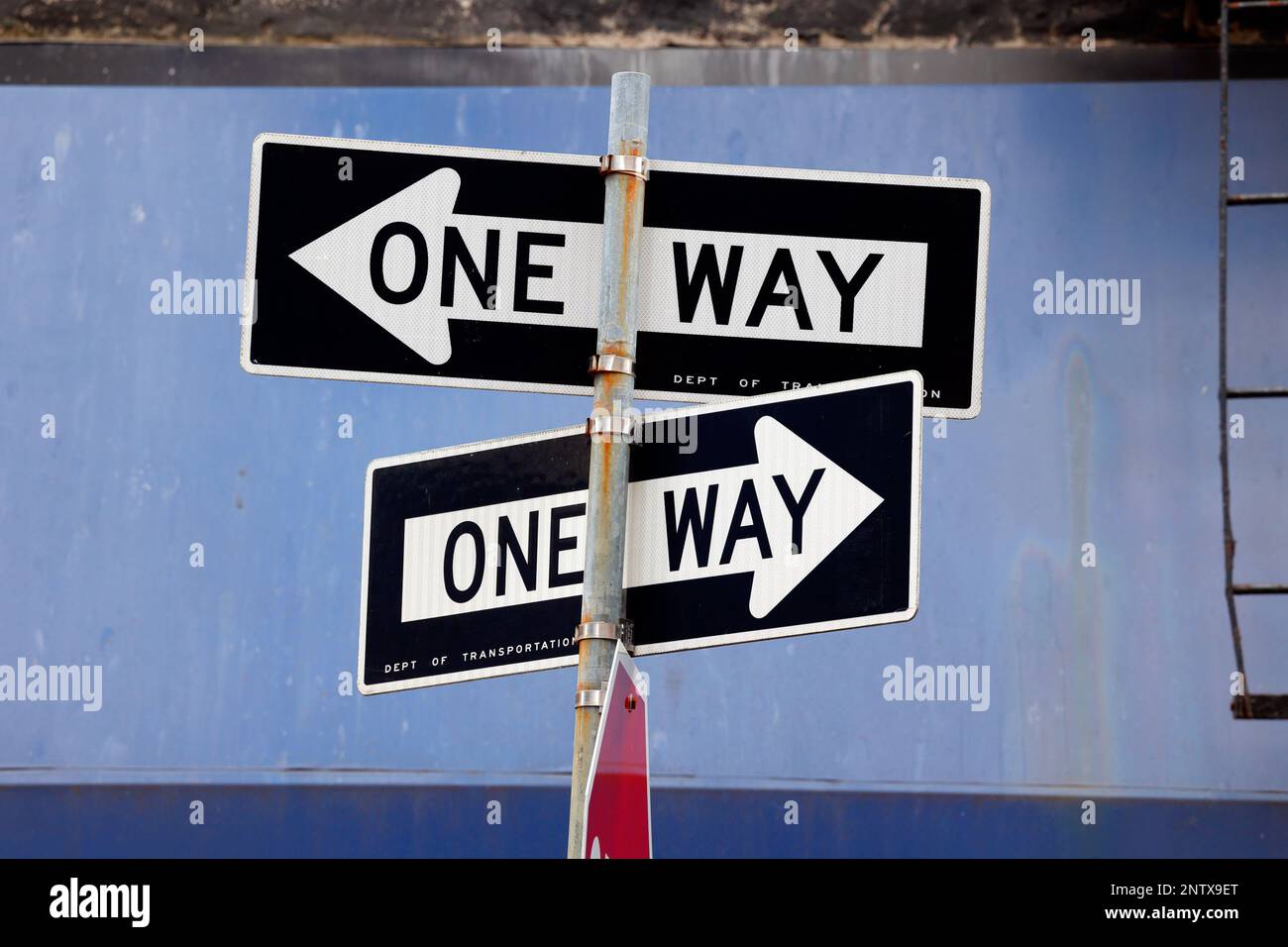 Contre les panneaux de signalisation à sens unique sur fond bleu Banque D'Images