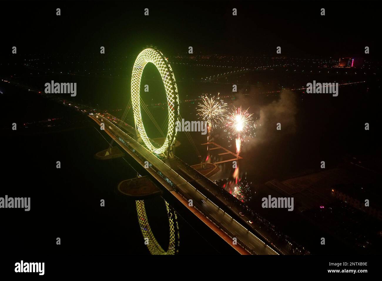A Ferris wheel called Eye of Bohai changes color in the night of Lantern Festival in Weifang city in east China's Shandong province Tuesday, Feb. 19, 2019. The 145-meter-tall rotating machine is the world's largest axis-less Ferris wheel, carrying 36 observation cabins. (FeatureChina via AP Images) Banque D'Images
