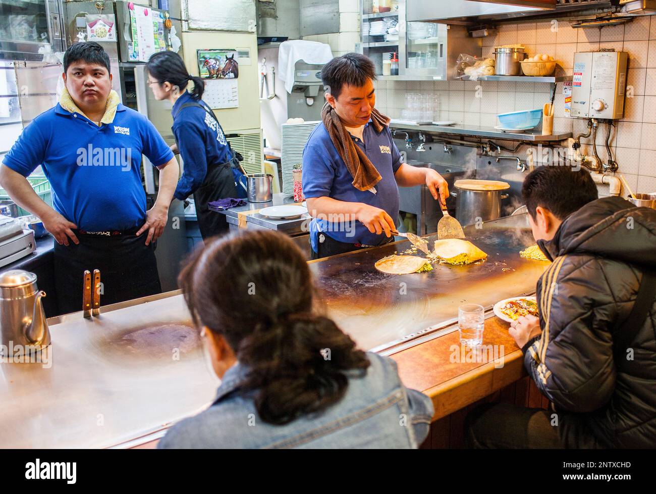 Okonomiyaki, chef au restaurant de l'okonomi-mura, Hiroshima, Japon Banque D'Images