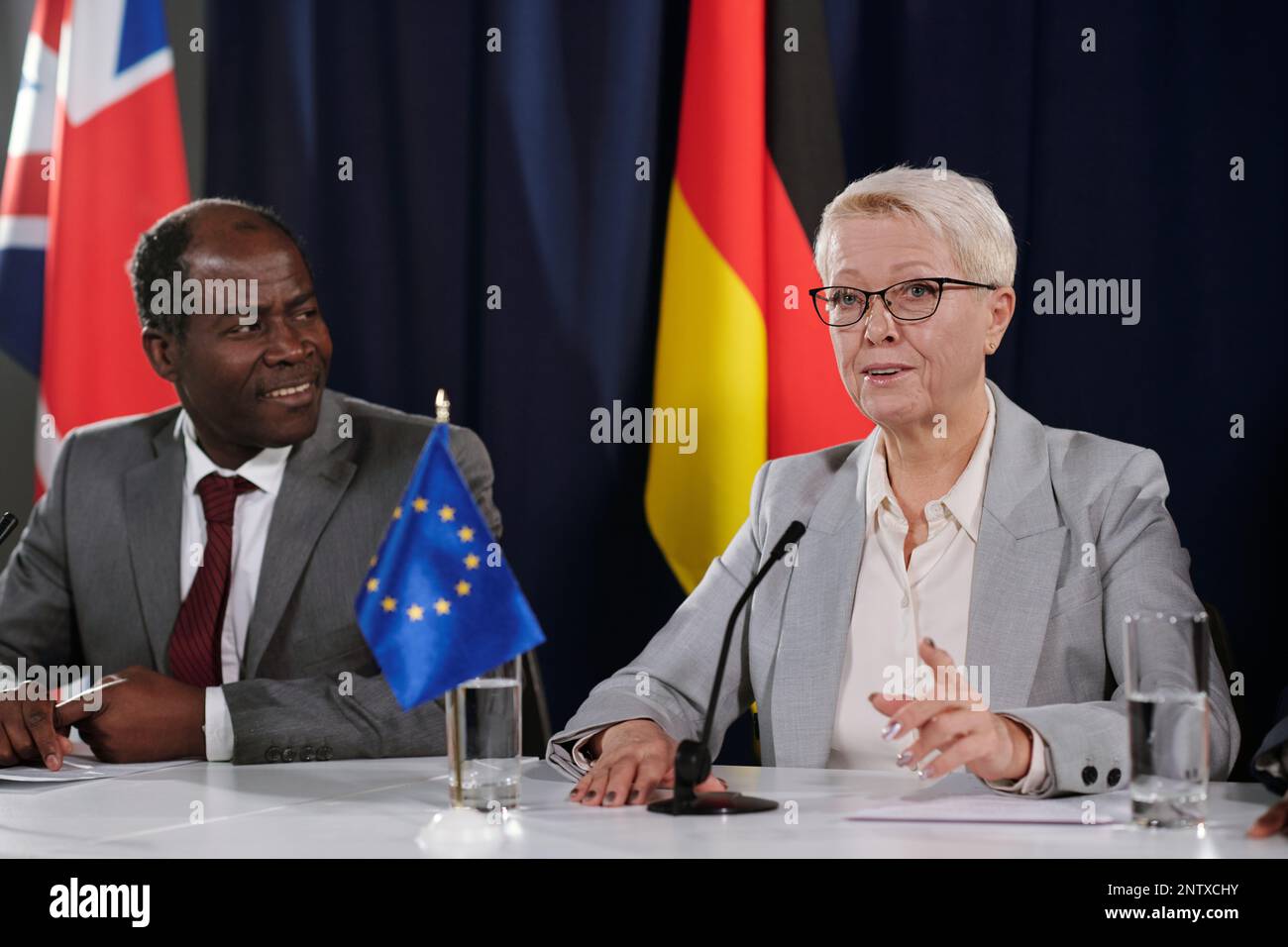 Femme blonde mature représentant de l'Union européenne portant un costume gris faisant un discours au sommet ou à un autre événement politique Banque D'Images